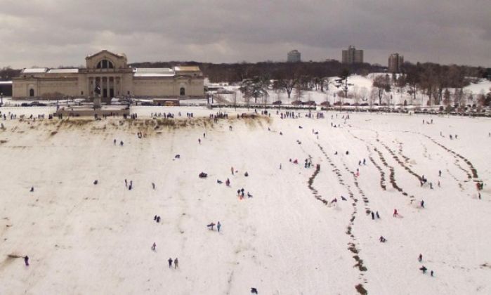 People sledding at Art Hill at Forest Park