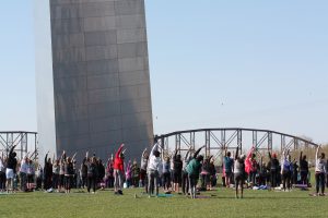 Visitors doing Yoga under the Gateway Arch