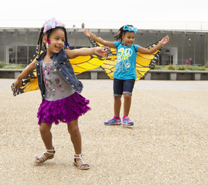 Two girls wearing butterfly wings at the Gateway Arch grounds