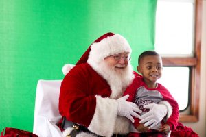 A little boy sits on Santa's lap and smiles for a photo aboard the Riverboats at the Gateway Arch