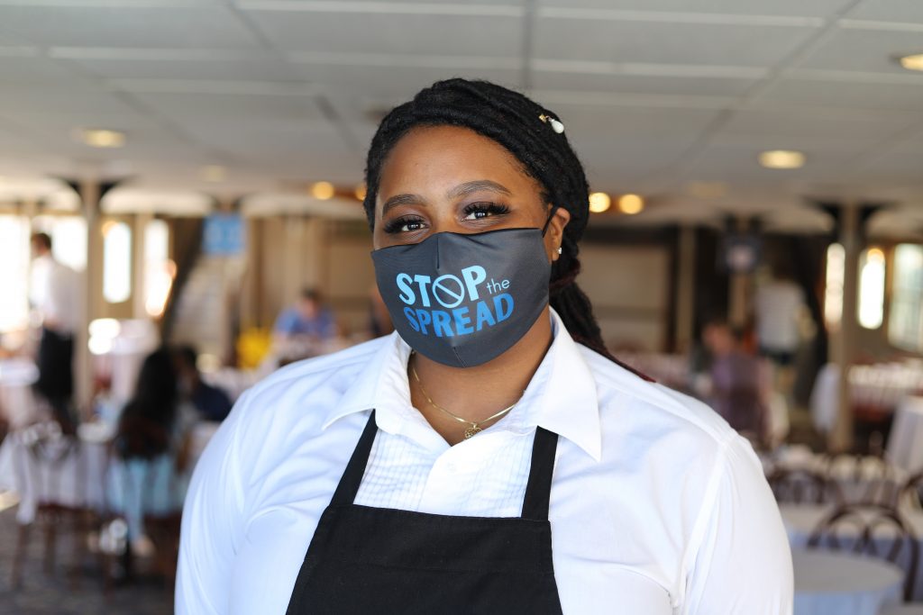 African American staff member with a mask that reads "Stop the Spread"