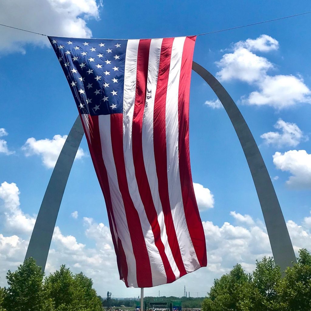 flag waving in front of the Arch