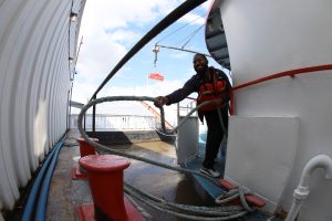 Deckhand Tremmel Wilson throws a rope to tie up a Riverboat at the Gateway Arch