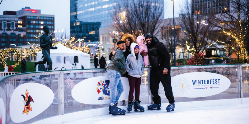 A family poses for a photo on the ice rink at Winterfest